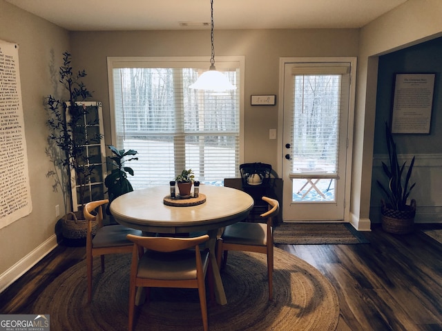 dining room featuring dark wood finished floors, visible vents, and a healthy amount of sunlight