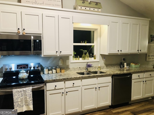 kitchen featuring stainless steel microwave, dishwasher, electric stove, white cabinets, and a sink