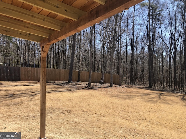 view of yard with a view of trees and fence