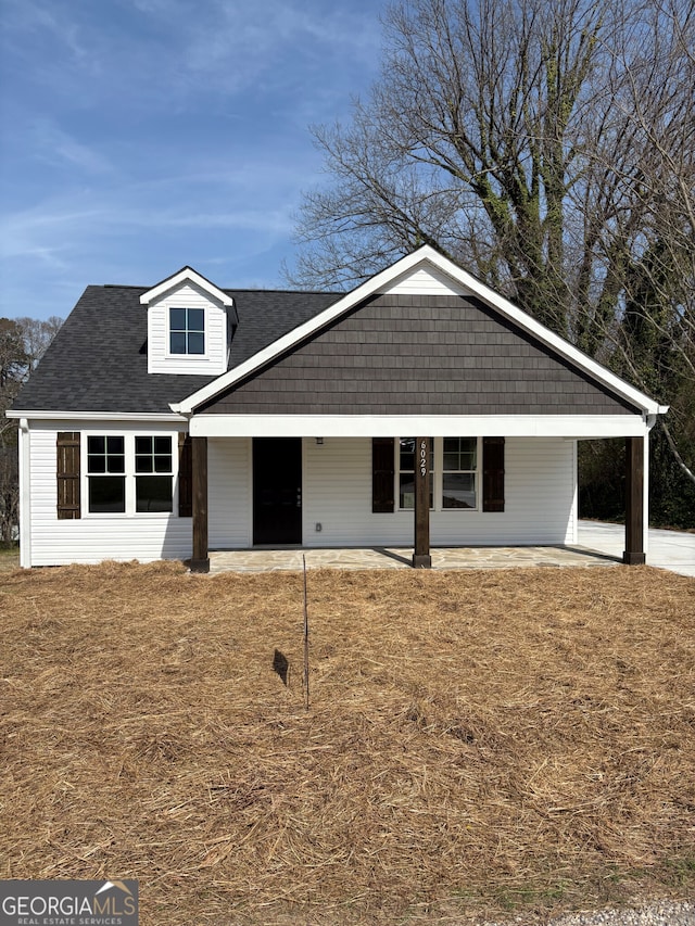 view of front of home with an attached carport and a shingled roof