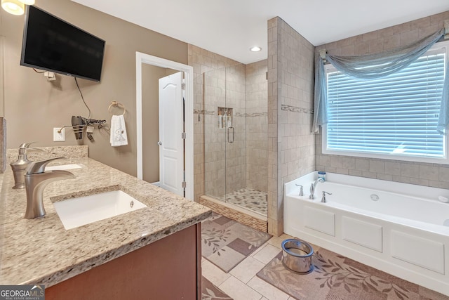 full bathroom featuring double vanity, a stall shower, a sink, tile patterned flooring, and a bath