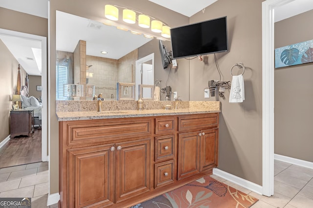 ensuite bathroom featuring visible vents, vanity, a tile shower, and tile patterned flooring