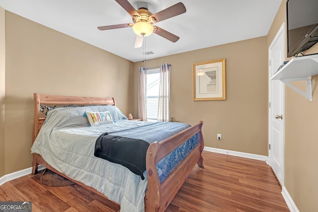 bedroom featuring visible vents, baseboards, and wood finished floors