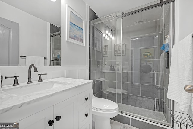 full bath featuring a stall shower, toilet, and vanity