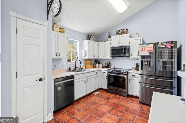 kitchen featuring white cabinets, appliances with stainless steel finishes, light countertops, and a sink