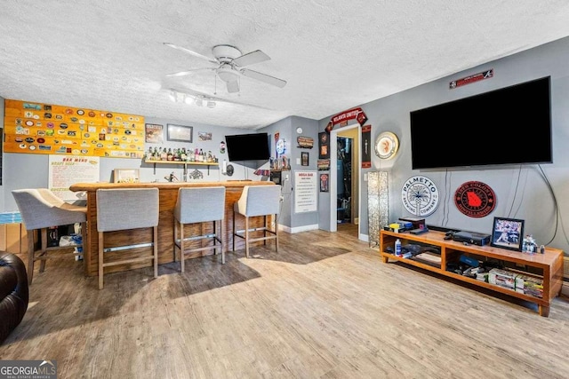 kitchen with a textured ceiling, ceiling fan, and wood finished floors