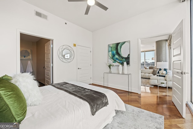 bedroom with ceiling fan, wood finished floors, visible vents, and baseboards