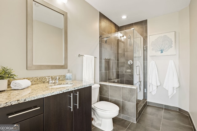 bathroom featuring tile patterned flooring, a stall shower, toilet, and vanity