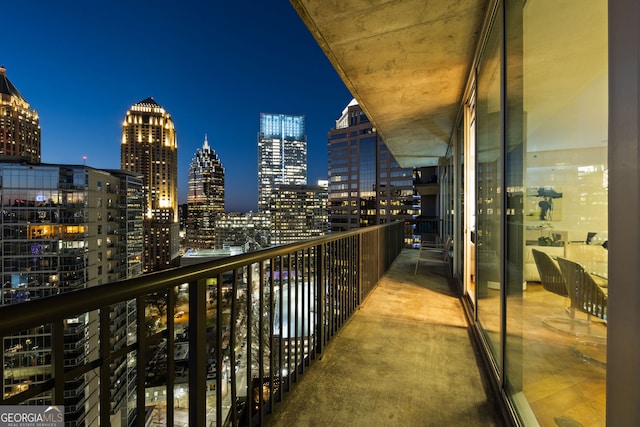 balcony at twilight featuring a view of city lights