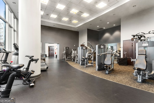 gym featuring a drop ceiling and a towering ceiling