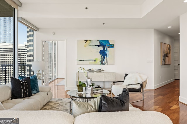 living room featuring floor to ceiling windows, recessed lighting, wood finished floors, and baseboards