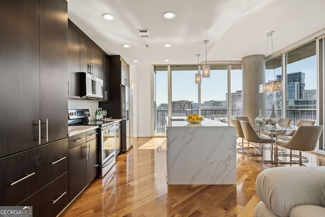 kitchen featuring a city view, visible vents, appliances with stainless steel finishes, and a kitchen island