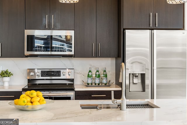 kitchen featuring dark brown cabinets, backsplash, appliances with stainless steel finishes, and a sink