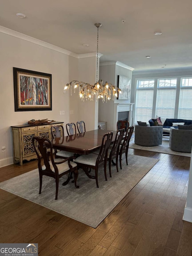 dining space with baseboards, a fireplace, dark wood-style floors, and crown molding