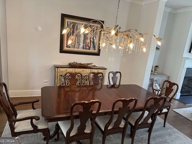 dining room with crown molding, wood finished floors, and baseboards