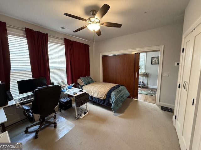 carpeted bedroom with baseboards, visible vents, a closet, and ceiling fan