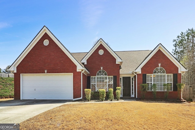 traditional-style home featuring a front lawn, brick siding, a garage, and driveway