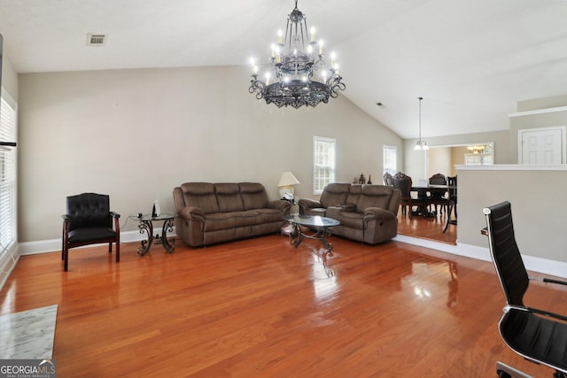 living room with baseboards, lofted ceiling, and light wood-style flooring