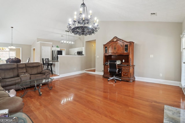 living area with visible vents, an inviting chandelier, and wood finished floors