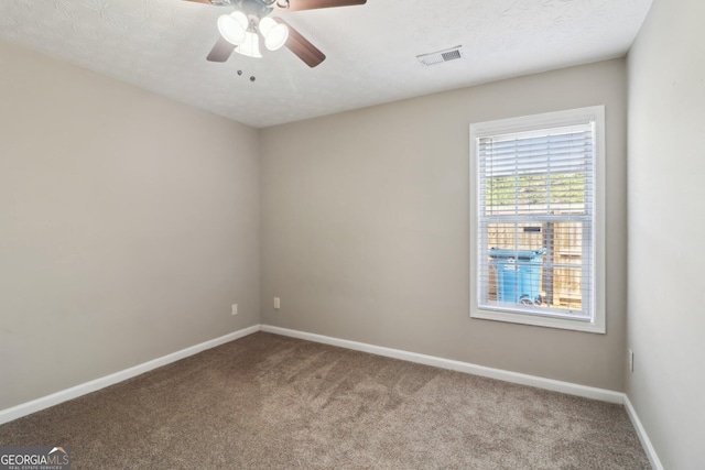 carpeted empty room featuring visible vents, ceiling fan, a textured ceiling, and baseboards