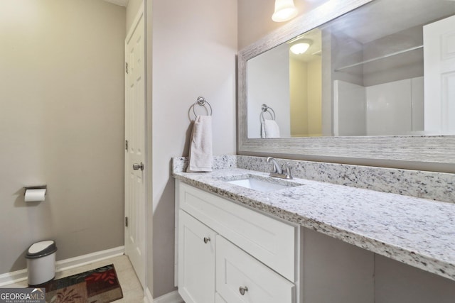 bathroom with tile patterned flooring, vanity, and baseboards