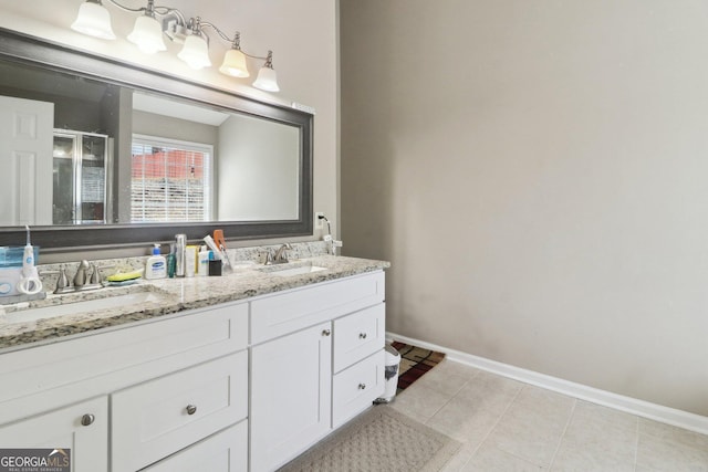 full bathroom featuring tile patterned flooring, double vanity, a stall shower, and a sink