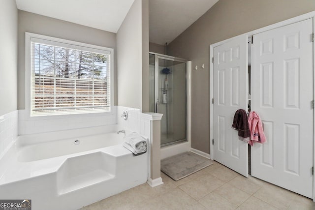 full bath featuring tile patterned flooring, a stall shower, and a garden tub