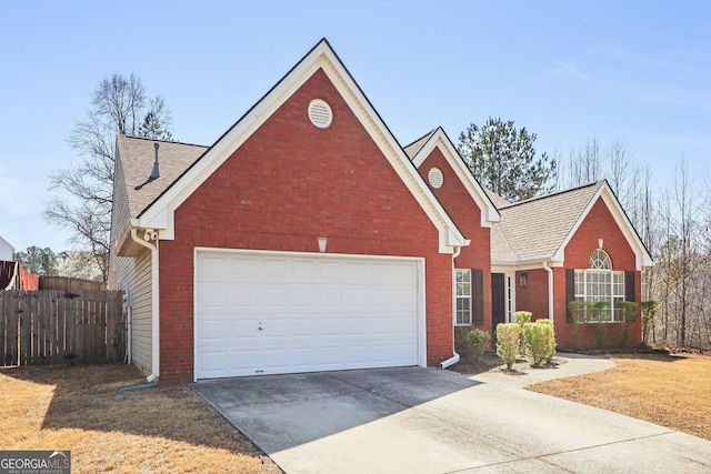 traditional home featuring brick siding, a shingled roof, fence, concrete driveway, and a garage