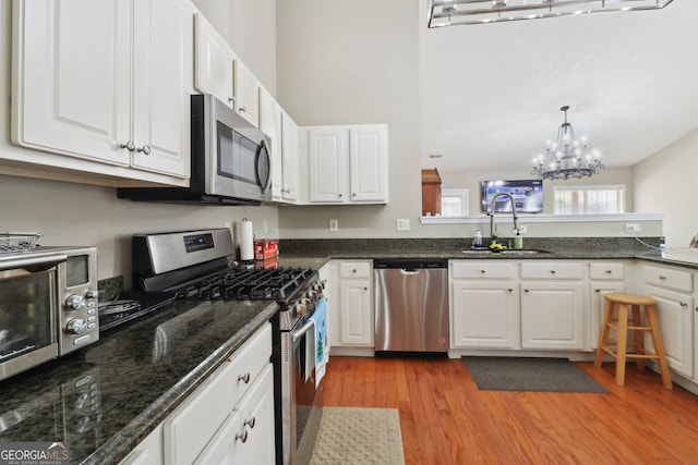 kitchen featuring a sink, light wood-type flooring, appliances with stainless steel finishes, and white cabinetry