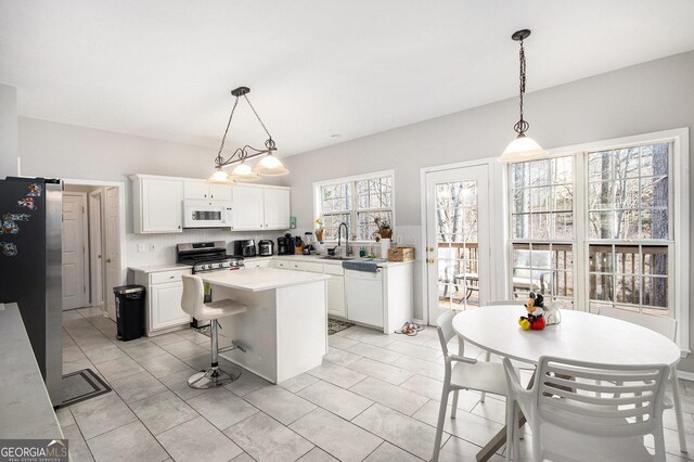 3550 Myrtlewood Chase NW, Kennesaw, GA 30144 - kitchen with appliances with stainless steel finishes, white cabinetry, light countertops, and decorative light fixtures