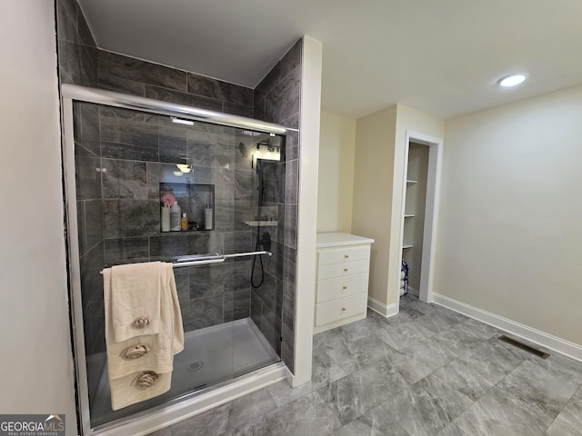 bathroom featuring visible vents, a shower stall, and baseboards