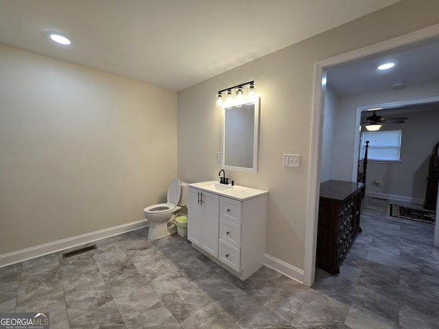 bathroom with visible vents, toilet, vanity, and baseboards