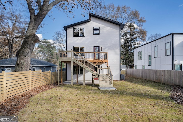 back of house with a fenced backyard, a wooden deck, stairs, and a yard