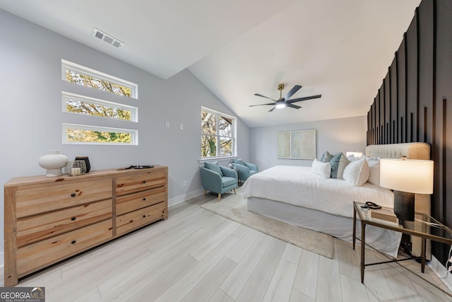 bedroom featuring visible vents, light wood-style flooring, baseboards, ceiling fan, and vaulted ceiling