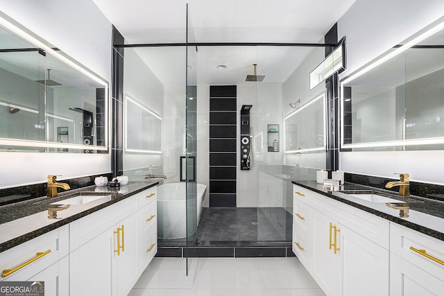 full bath with a shower stall, two vanities, and a sink