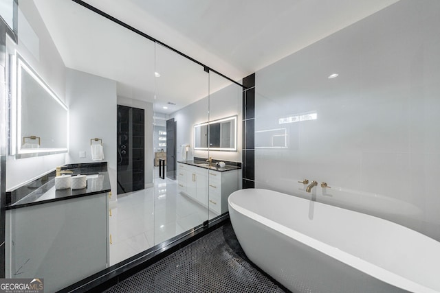 bathroom with a freestanding tub, two vanities, recessed lighting, a shower stall, and tile walls