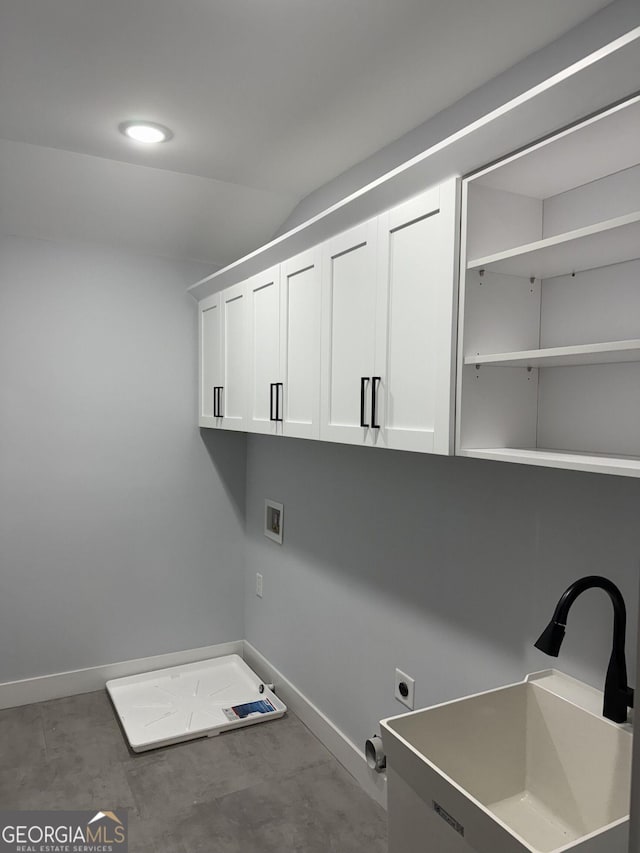 laundry room with baseboards, washer hookup, cabinet space, electric dryer hookup, and a sink