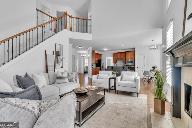 1654 Summersweet Ln, Dacula, GA 30019 - living area featuring a high ceiling, stairway, a chandelier, and a tile fireplace