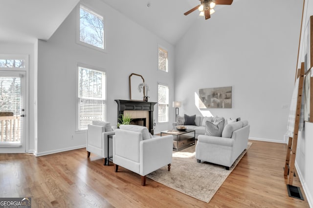 1654 Summersweet Ln, Dacula, GA 30019 - living room featuring high vaulted ceiling, a tile fireplace, plenty of natural light, a ceiling fan, and wood finished floors