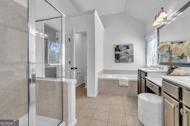 bathroom featuring tile patterned floors, a garden tub, toilet, a stall shower, and vaulted ceiling