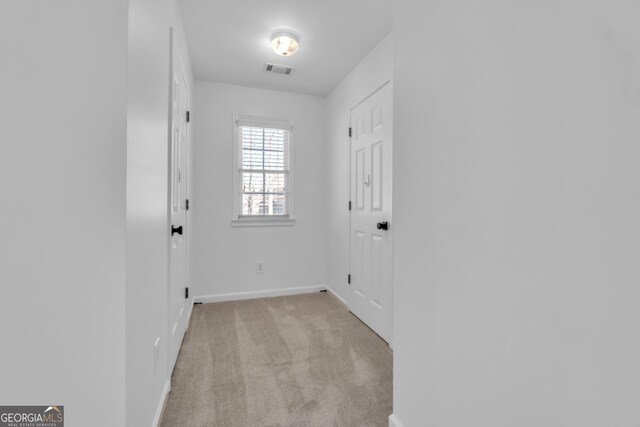 spare room featuring visible vents, baseboards, lofted ceiling, light carpet, and a ceiling fan