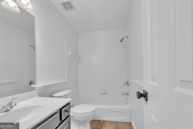 bathroom featuring tile patterned flooring, visible vents, washtub / shower combination, toilet, and vanity