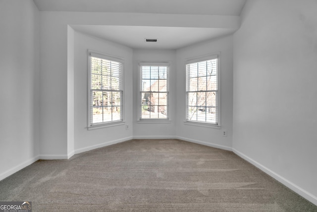 unfurnished room with baseboards, carpet floors, and visible vents