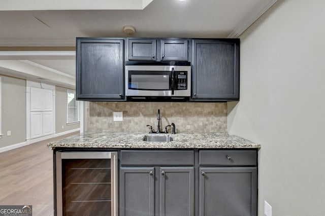 1654 Summersweet Ln, Dacula, GA 30019 - kitchen featuring stainless steel microwave, wine cooler, backsplash, crown molding, and light wood finished floors