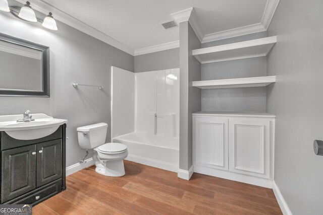 bathroom with wood finished floors, visible vents, and ornamental molding