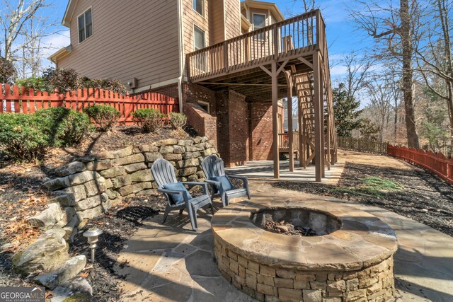 back of property with brick siding, stairway, fence private yard, and a deck