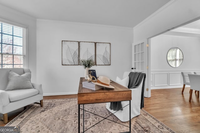 home office featuring a decorative wall, crown molding, and wood finished floors