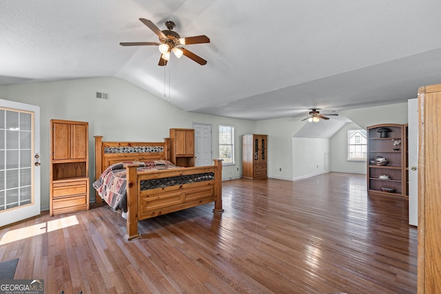 bedroom featuring visible vents, multiple windows, lofted ceiling, and hardwood / wood-style flooring