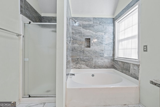 bathroom featuring a garden tub, a shower stall, and a textured ceiling