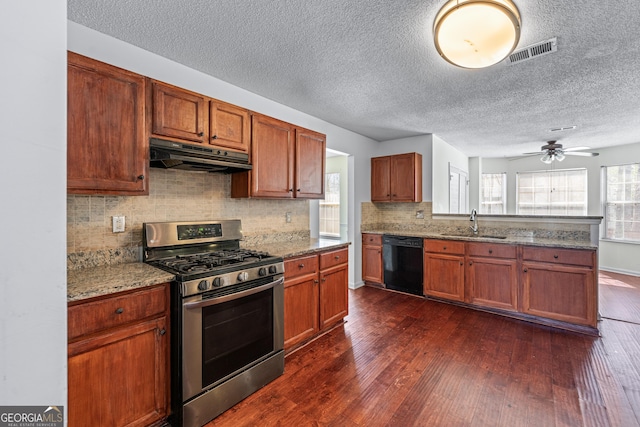 kitchen featuring visible vents, stainless steel range with gas cooktop, dark wood-type flooring, under cabinet range hood, and dishwasher